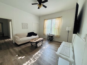 A living room with a sofa, coffee table, and a ceiling fan. - Cozy 2BR Retreat • TVs in Every Room • Streaming Included (Shreveport)