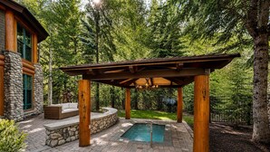 A covered outdoor area with a pool, stone walls, and wooden pillars. - Private Sun Valley Lodge | Walk to Lift + Hot Tub (Ketchum)