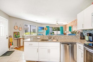A kitchen with white cabinets, a granite countertop, a dishwasher, and a stove. - Sandy Solstice 5A-Beachside Condo-Sleeps 6 (Destin)