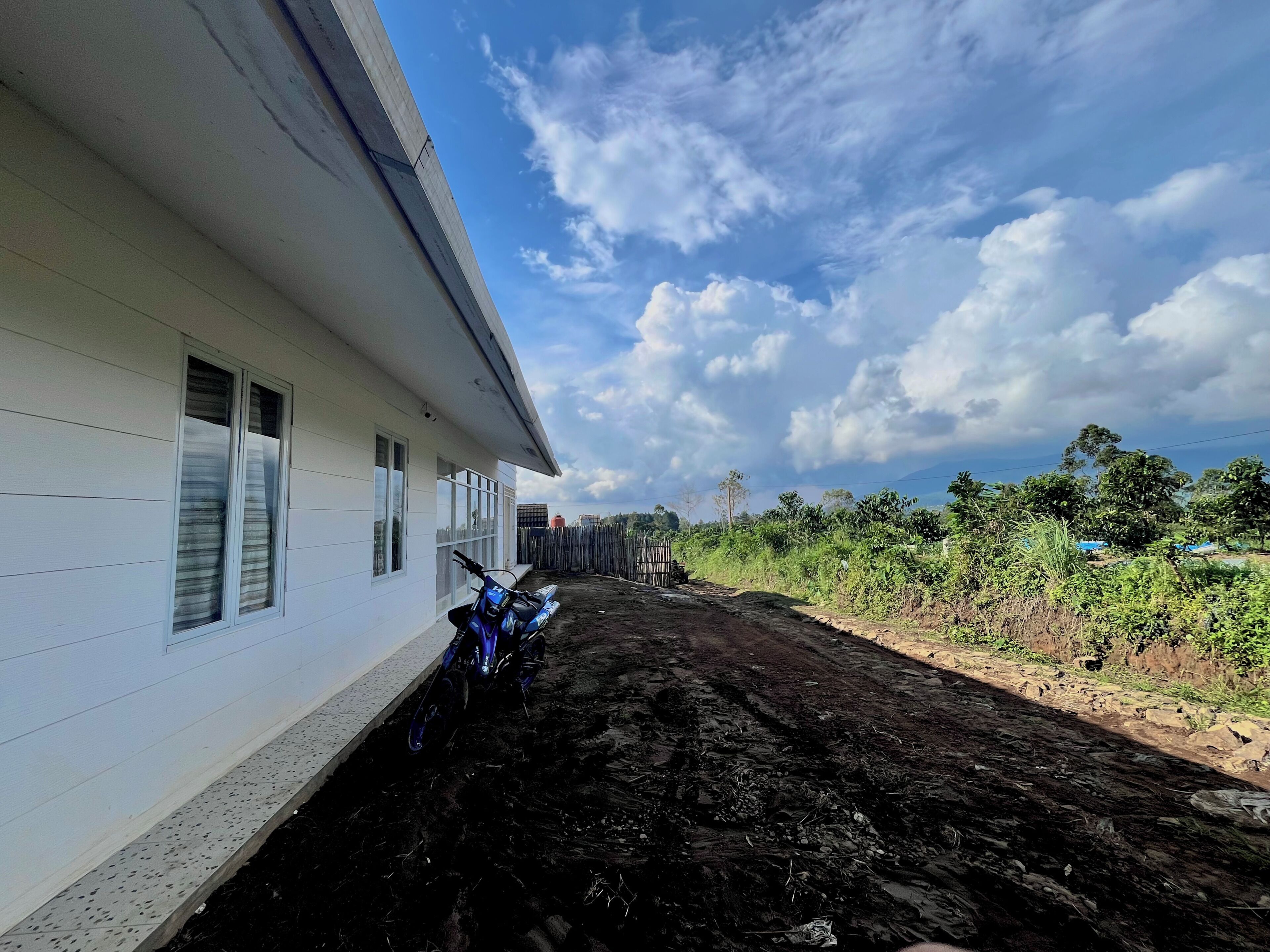 Un bâtiment avec une allée pavée et une moto garée devant.