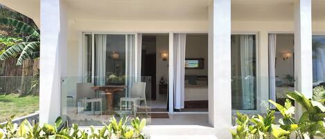 A modern hotel with a glass entrance, a dining area with a table and chairs, and a view of the interior.