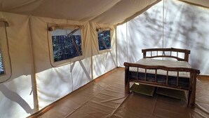 Una tienda de campaña con cama y ventanas.