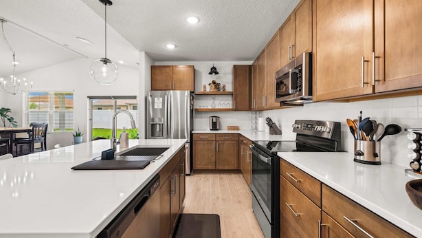A modern kitchen with wooden cabinets, stainless steel appliances, and a large island. - Spacious Modern Villa with Private Yard, Ocala (Ocala)
