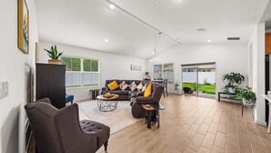 A spacious living area with a sofa, armchairs, a coffee table, and a dining table. - Spacious Modern Villa with Private Yard, Ocala (Ocala)