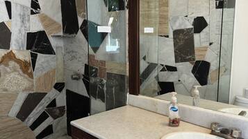 Habitación doble Deluxe, baño privado, vista al jardín | Baño | Regadera y toallas