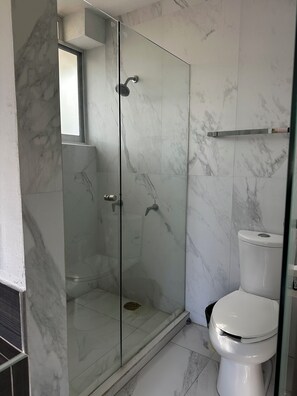 A bathroom with a glass-enclosed shower, a toilet, and marble flooring. - Casa vintage & eventos (Yautepec)