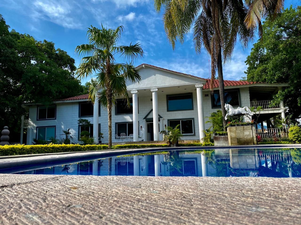 Un bâtiment à deux étages avec une piscine devant.