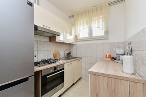 Eine moderne Küche mit einem Gasherd, Backofen und einer Kaffeemaschine.