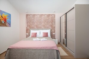 Ein Schlafzimmer mit einem Bett, Nachttischen, einem Kleiderschrank und einem Gemälde an der Wand.