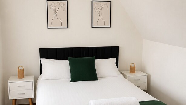 A bedroom with a bed, two bedside tables, a lamp, and two wall-mounted pictures. - Chic 5Bed City Centre Home-Sleeps9-Near QMC&Castle (Nottingham)