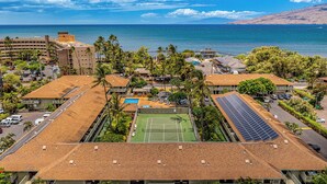 Ein Wohngebiet mit Tennisplatz, Solaranlage und Blick auf den Ozean.