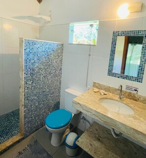 Ein Badezimmer mit Dusche, Toilette, Waschbecken und Spiegel.