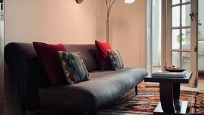 A modern living room with a sofa, decorative pillows, a floor lamp, and a coffee table. - Stay with a local in Brownstone Brooklyn's Carroll Gardens (Brooklyn)