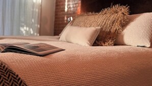 A bed with a patterned bedspread, a pillow, and an open magazine. - Stay with a local in Brownstone Brooklyn's Carroll Gardens (Brooklyn)