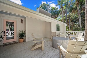 A wooden deck with outdoor seating, a door, and a window. - Classic Beach Home, Golf Cart Included - 703 Skip Jack (Fripp Island)