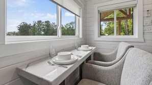 Une cuisine avec une fenêtre, un comptoir et une chaise.