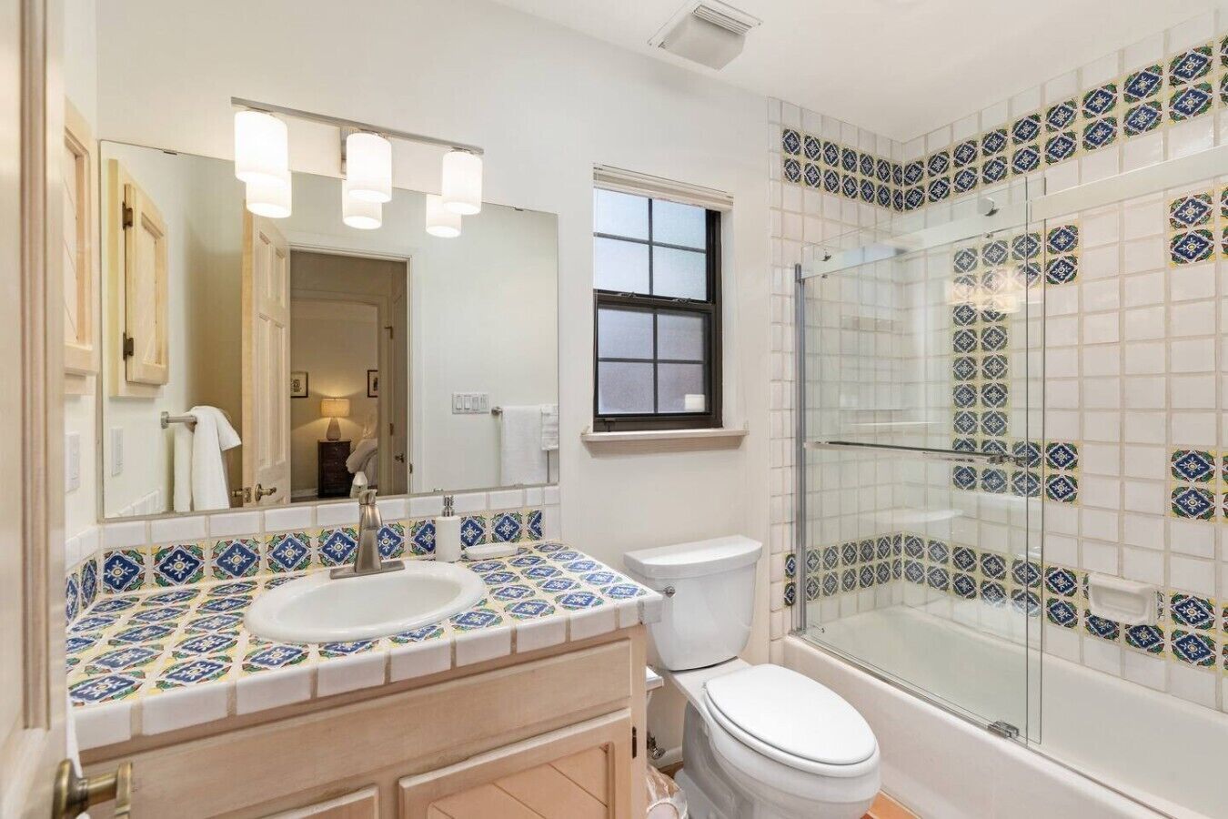 A bathroom with a sink, toilet, and glass-enclosed shower.