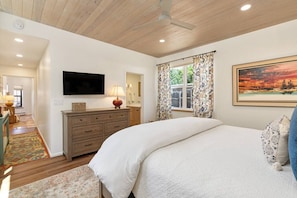 A bedroom with a bed, dresser, TV, and a painting. - Two large patios with fountains and beautiful landscaping inside a private space. (Santa Fe)
