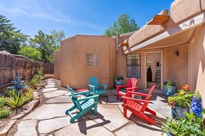 A patio with Adirondack chairs, a stone pathway, and potted plants. - Two large patios with fountains and beautiful landscaping inside a private space. (Santa Fe)
