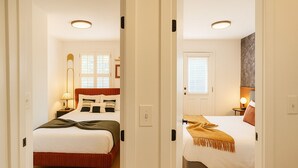 Two bedrooms with beds, bedside tables, lamps, and windows.
