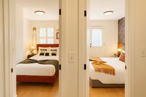 Two bedrooms with beds, bedside tables, lamps, and windows.