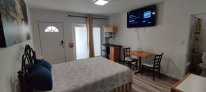 A room with a bed, a desk, a chair, a television, and a door. - Comfy Studio by Baseball Stadium. Own Entrance (Miami)