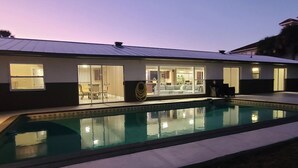 Una casa moderna con piscina, amplias ventanas y un interior luminoso.
