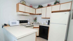 A compact kitchen with a microwave, stove, and dishwasher.