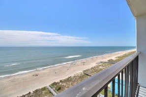 Ein Balkon mit Blick auf Strand und Meer.