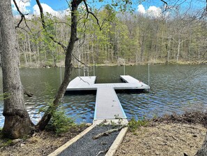 Eine Steganlage, die in einen See hineinreicht, umgeben von Bäumen.