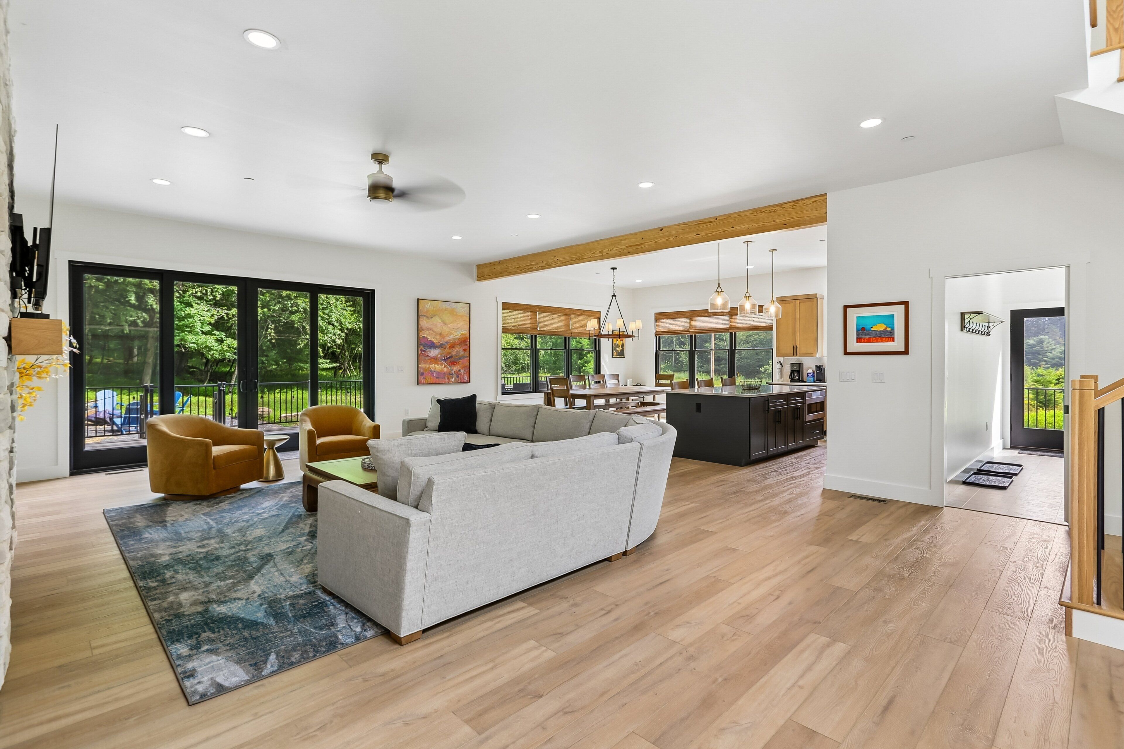A modern living room with a sofa, chairs, and a dining area.