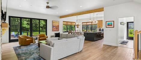 A modern living room with a sofa, chairs, and a dining area.
