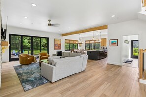 A modern living room with a sofa, chairs, and a dining area. - Experience luxury at Summit and Shore, a 5-bedroom retreat in beautiful Swanton, MD. (Swanton)