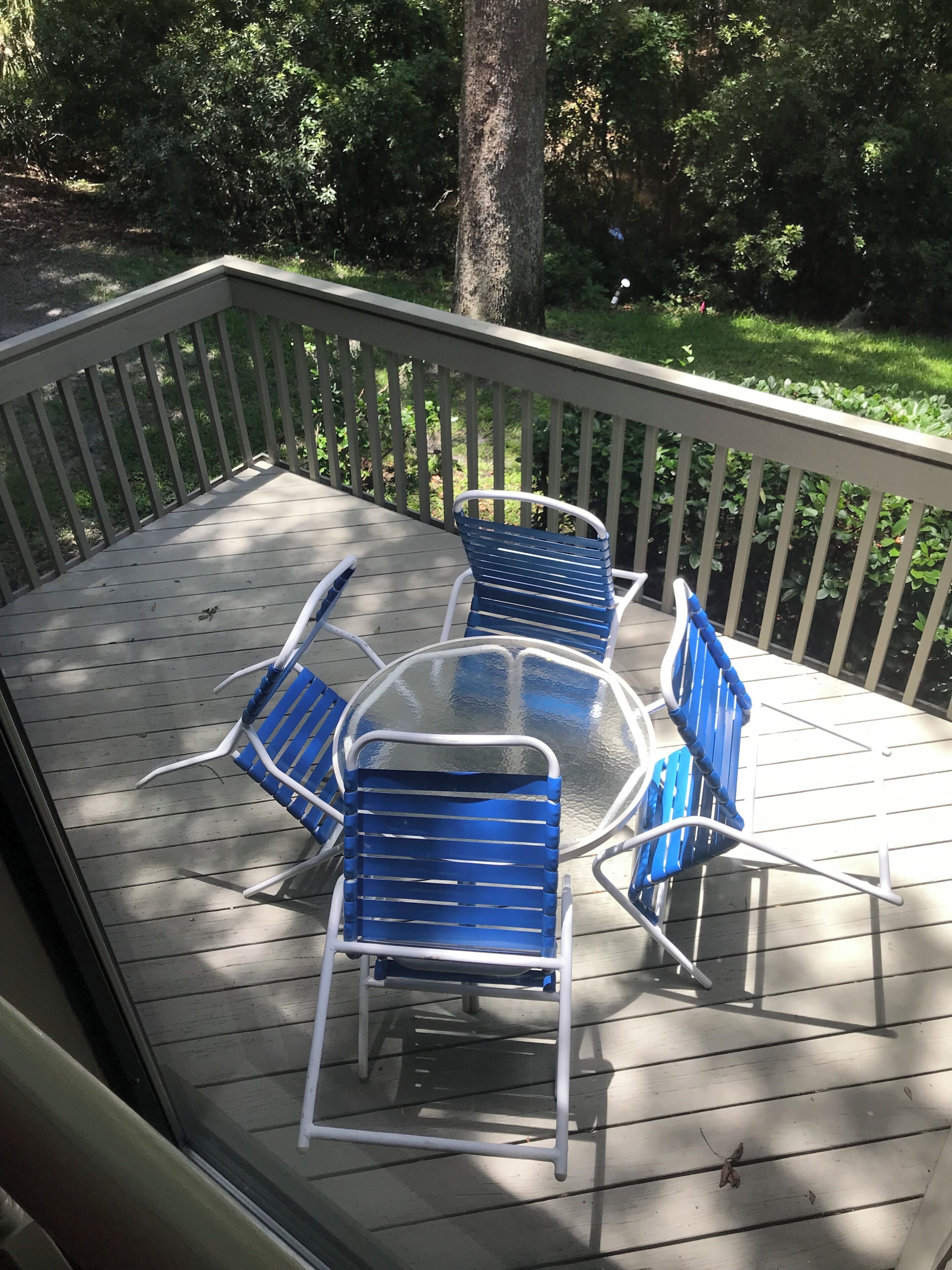 A covered outdoor deck with a table and four chairs.
