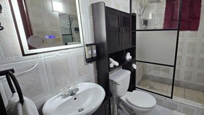 Ein Badezimmer mit Waschbecken, Toilette und Duschbereich.