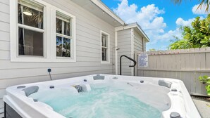 A hot tub outside a house with a wooden fence and a sign. - NEW: Cozy Home w/ Hot tub & Beach Essentials! (Lake Worth Beach)