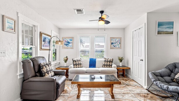 A living room with a sofa, a recliner, a rocking chair, a coffee table, and a ceiling fan. - NEW: Cozy Home w/ Hot tub & Beach Essentials! (Lake Worth Beach)
