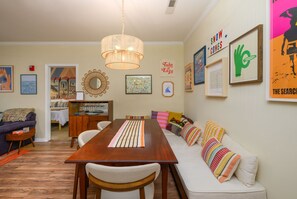 Een eetruimte met een houten tafel, stoelen en een hanglamp.