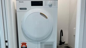 A stacked washer and dryer unit with energy and water efficiency ratings. - Modern Family Home in Tawa. 
Pet Friendly Property (Wellington)