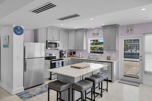 A modern kitchen with stainless steel appliances, a large island, and bar stools. - Port Palermo - Canal Home w/Dockage, Pet Friendly! (Islamorada)