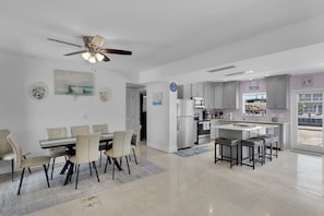 A modern kitchen with a central island, a dining area with a table and chairs, and a ceiling fan. - Port Palermo - Canal Home w/Dockage, Pet Friendly! (Islamorada)
