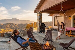 A patio with outdoor seating, a fire pit, and a view of mountains. - Casa Sole | Pool | Spa | Near Palm Springs (Morongo Valley)