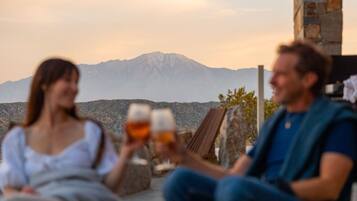 Two people sitting outdoors with a mountain in the background.