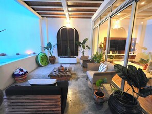 A cozy living area with a sofa, a coffee table, and potted plants. - Ava 19 Adults Only Villa - Bed & Breakfast (Puerto Vallarta)