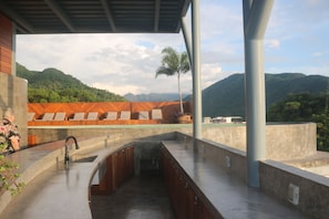 A rooftop terrace with a view of mountains, a pool, and a seating area. - Ava 19 Adults Only Villa - Bed & Breakfast (Puerto Vallarta)