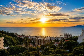 A coastal cityscape at sunset with buildings and a clear view of the sea. - Ava 19 Adults Only Villa - Bed & Breakfast (Puerto Vallarta)