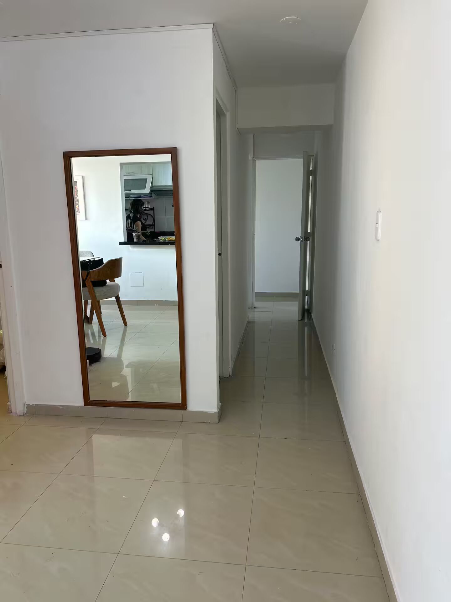 A modern interior with a hallway leading to a kitchen area.