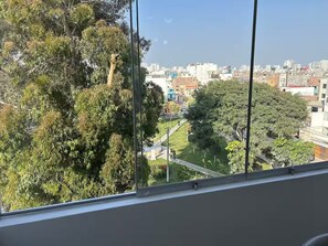 Blick aus einem Fenster auf eine Stadtlandschaft mit Gebäuden und Bäumen.
