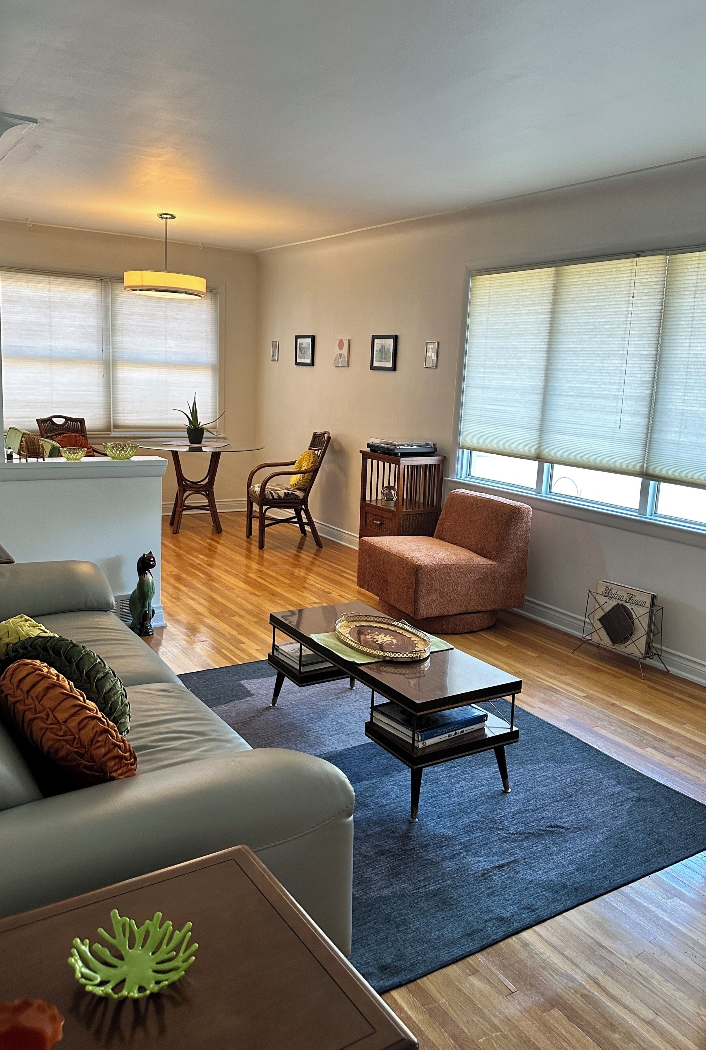 Ein Wohnzimmer mit einer Couch, Sesseln, einem Couchtisch und einem Esstisch.