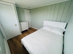 A bedroom with a bed, a dresser, and a door. - The perfect family- and pet-friendly getaway steps from the sandy beach (Sandwich)